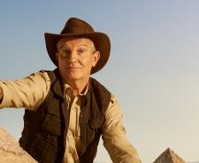 Bradley Walsh looms over the Great Pyramids and lifts one up with his finger