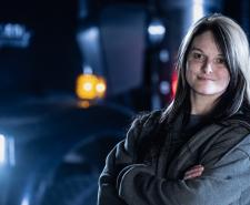 Lisa Kelly standing with her arms crossed in front of a truck