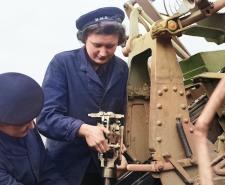 Colourised photo of two Wrens reassembling a pom-pom gun in WWII