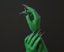 Green witch hands with long black nails