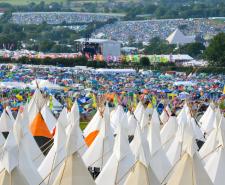 Fields of tents at Glastonbury overlooking a stage