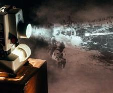 Photo of a projector and a World War Two image of a flugzeugträger bombing