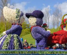 A man and a woman made out of flowers on a float during a Bloemencorso Bollenstreek precession