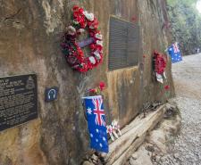 A memorial for Allied POWs at the Hellfire Pass. Poppies, plaques and Australian flags are mounted on the side of a rock in the jungle