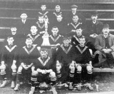 Team photo of West Auckland FC with the trophy they won in 1909