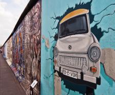 Graffiti of a car crashing through the Berlin Wall